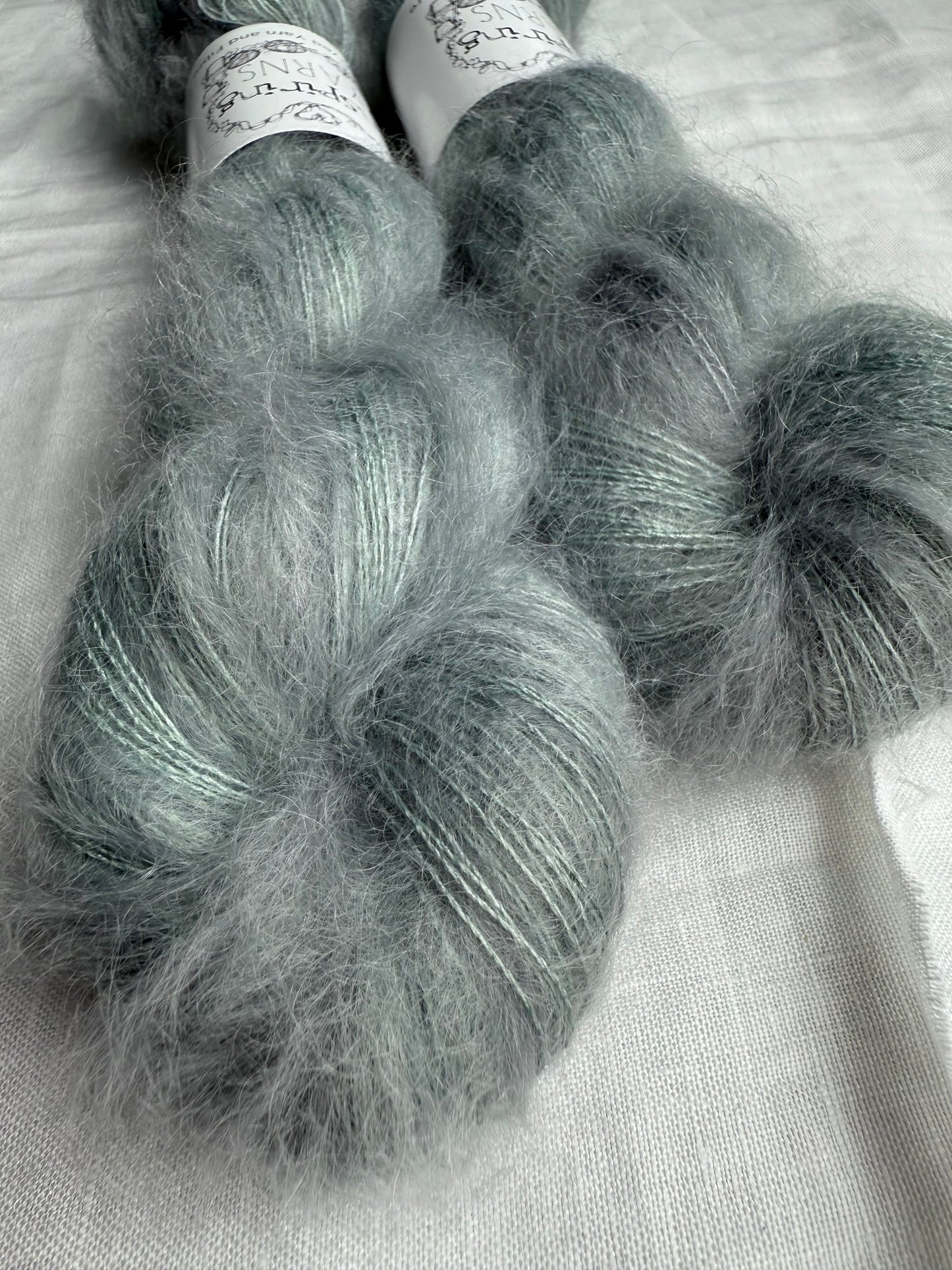 Two skeins of gray yarn on a light background.