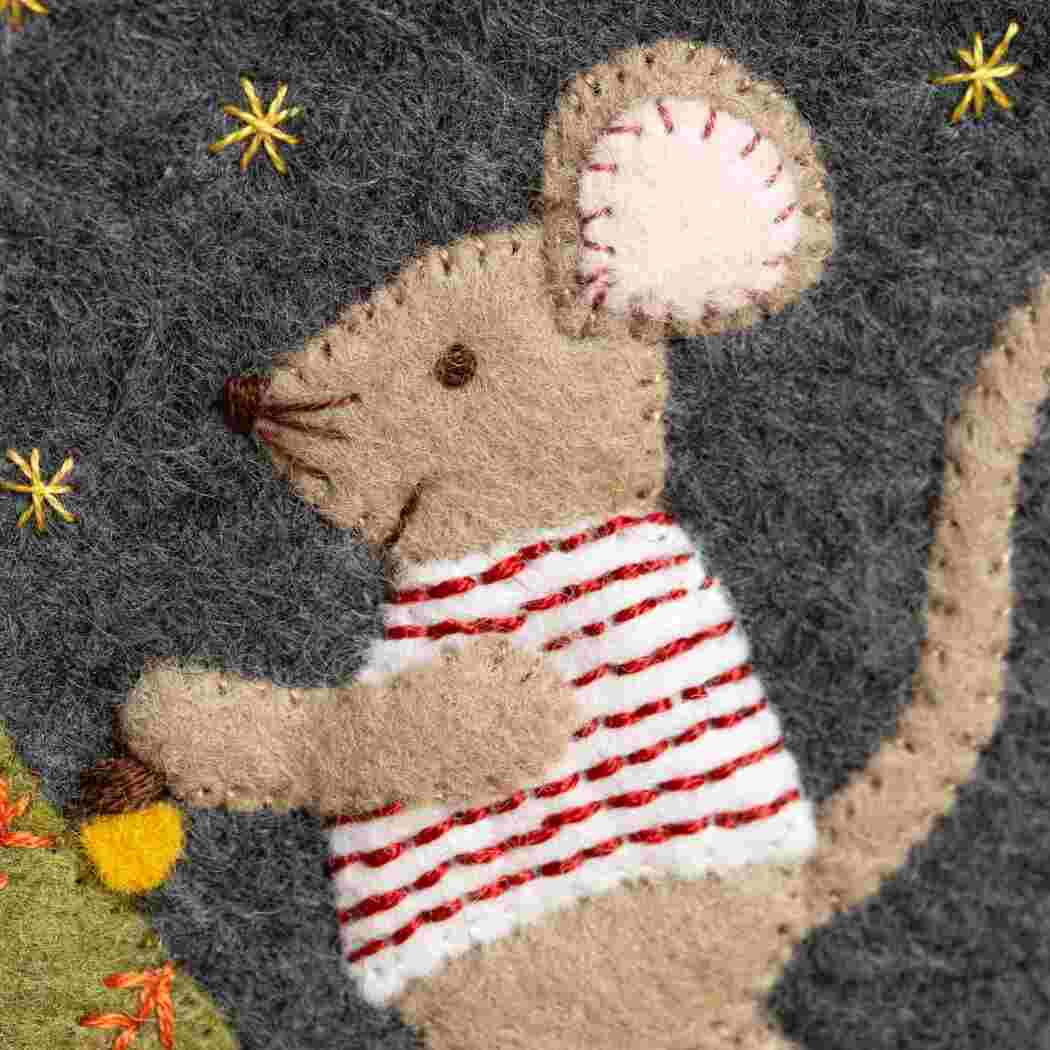 Close up of a felt embroidered mouse wearing a white and red striped top and decorating a tree