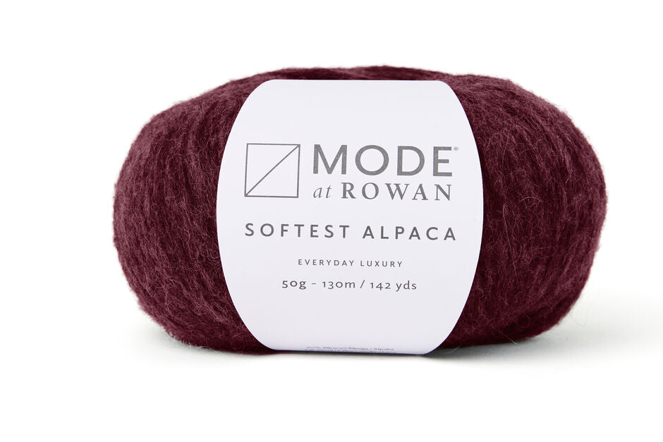 ball of rowan softest alpaca in a deep cranberry with white rowan label and grey writing on a plain white background.