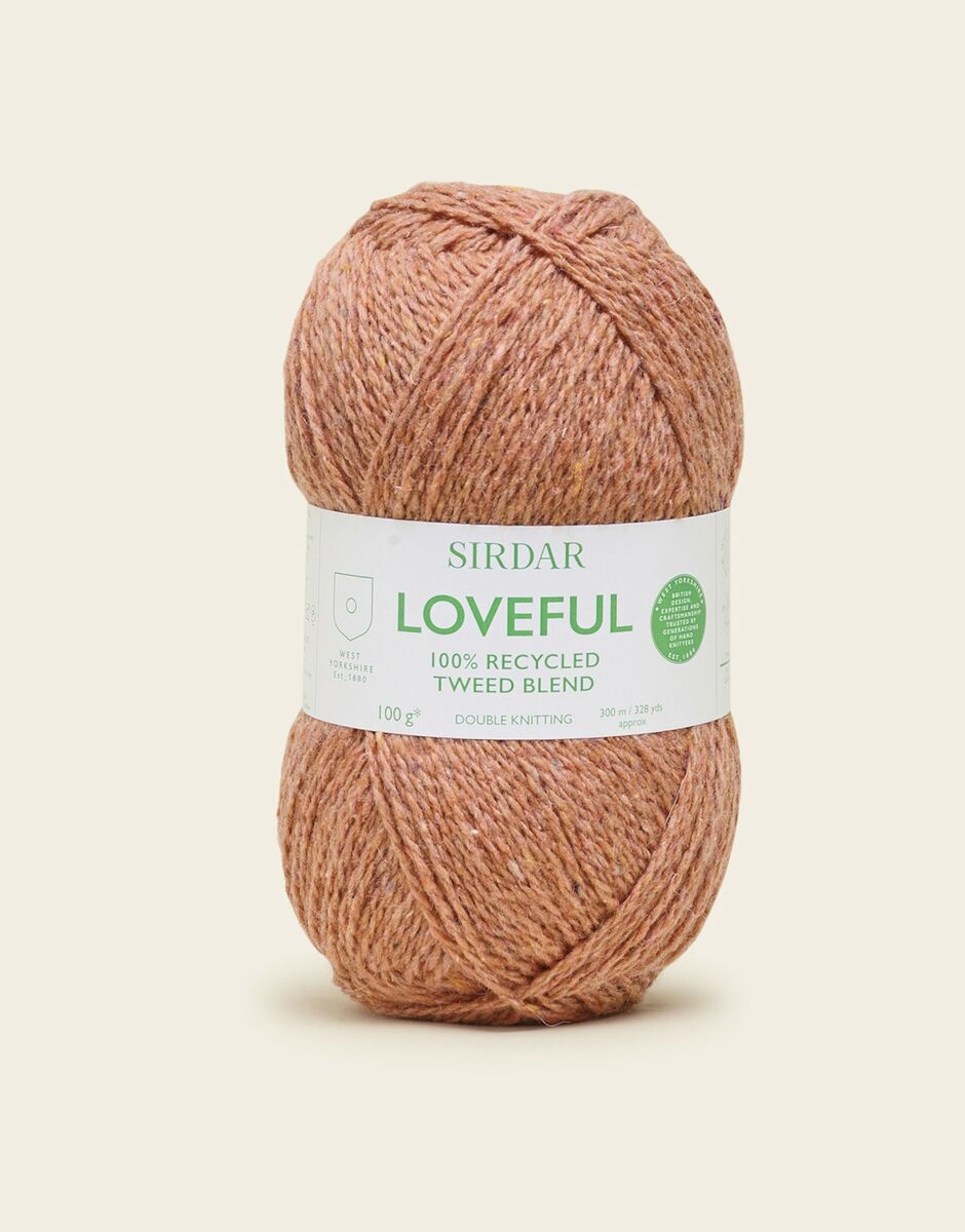 Ball of rust yarn with Sirdar Loveful label on a light beige background