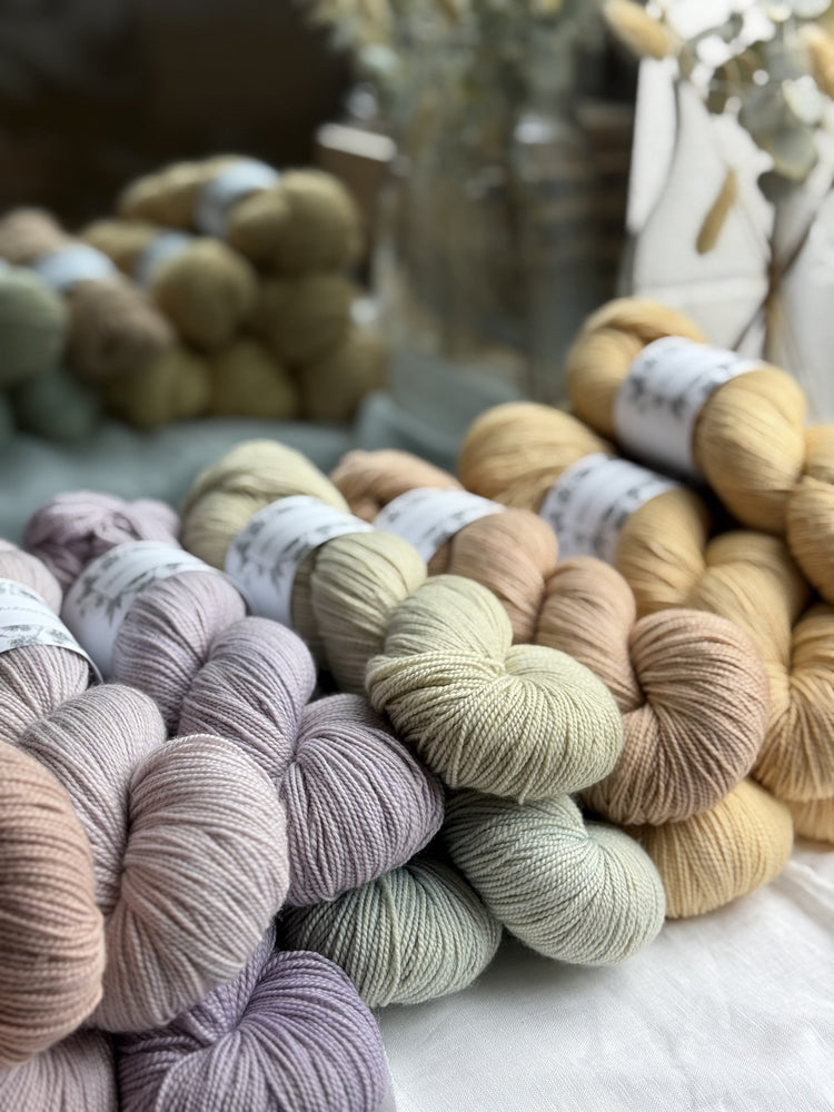 Selection of skeins of Herbarium Dyeworks yarn in pastel shades.
