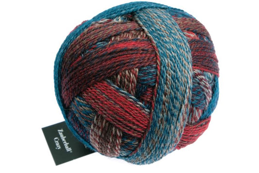 Image shows wound ball of Schoppel Zauberball Crazy 4ply/sock.  The colour is 1507 Autumn Wind/Herbstwind with shades of light to mid blue, rust and brown.