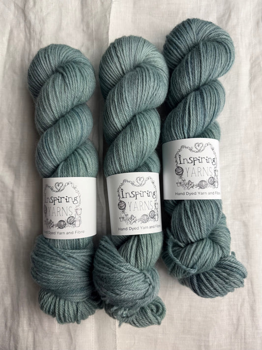 Three skeins of pale teal tonal yarn labelled Inspiring Yarns on a white background
