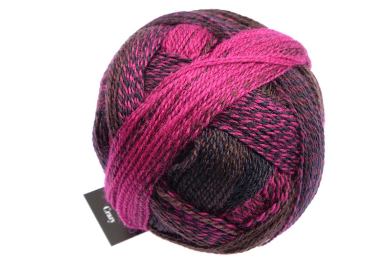 Image shows wound ball of Schoppel Zauberball Crazy 4ply/sock.  The colour is 2082 Charisma with shades of deep cerise and inky blue.