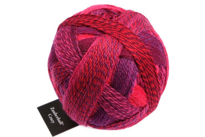 Image shows wound ball of Schoppel Zauberball Crazy 4ply/sock.  The colour is 2095 Indian Red/Indisch Rosa, with shades of coral, purple and pink