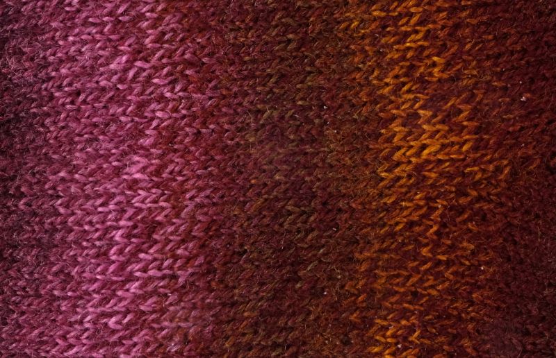 Image shows knitted swatch for  Schoppel Zauberball Crazy 4ply/sock.  The colour is 2312 Piano Bar,  with shades of greens, blues, mauves and yellow.
