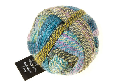 Image shows wound ball of Schoppel Zauberball Crazy 4ply/sock.  The colour is 2355 Garden Party/Gartenparty, with shades of mauve, blue, turquoise and yellow.