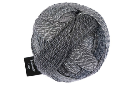 Image shows wound ball of Schoppel Zauberball Crazy 4ply/sock.  The colour is 2428 Mud Pack/Schlammpackung, with shades of dark and light greys,