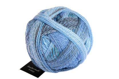 Image shows wound ball of Schoppel Zauberball Crazy 4ply/sock.  The colour is 2438 Indigo, with shades of light and dark blue and grey.