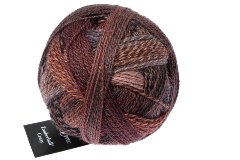 Image shows wound ball of Schoppel Zauberball Crazy 4ply/sock.  The colour is 2544 Late Autumn by Kieran Foley, with shades of brown, grey and neutrals.