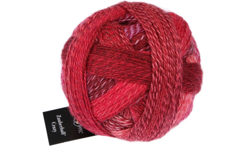 Image shows wound ball of Schoppel Zauberball Crazy 4ply/sock.  The colour is 2620 Red in a Suit/Rot in Anzug , with shades of pink, red and wine.