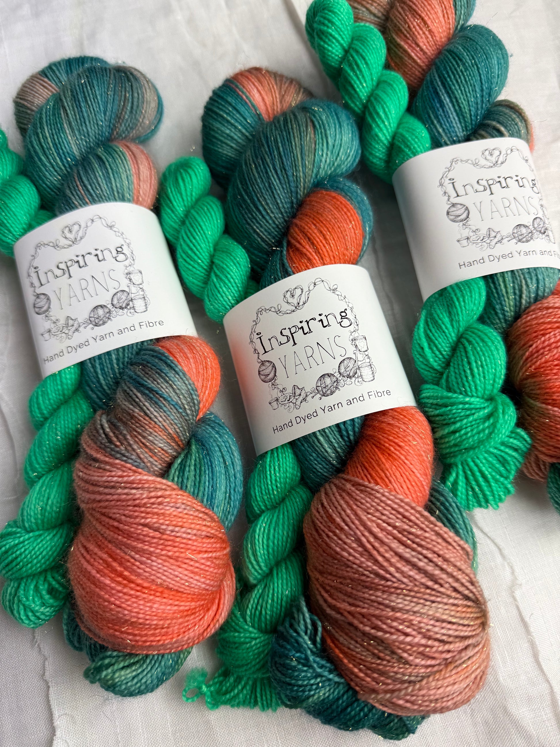 Colourful yarn skeins with inspiring  yarns labels on a textured surface.