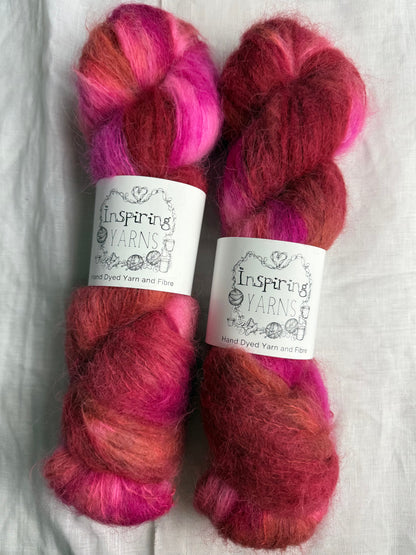 two skeins of pink and brown yarn with inspiring yarns labels on a wite background.