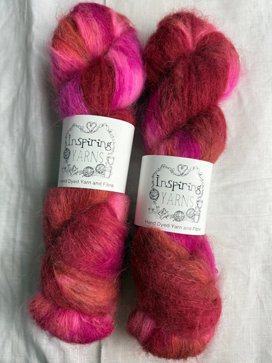 two skeins of pink and brown yarn with inspiring yarns labels on a wite background.