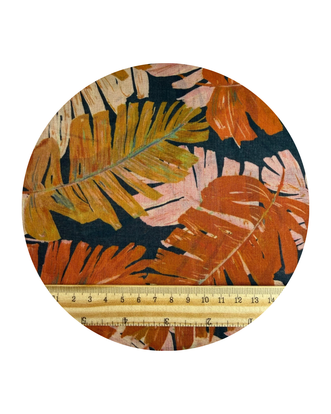 Del Mar design from Sunday Collection for Cloud9 Fabrics, a pattern of palm leaves in orange and pink on a dark blue background. A round swatch shown on a white background with a wooden ruler in centimeters for scale.