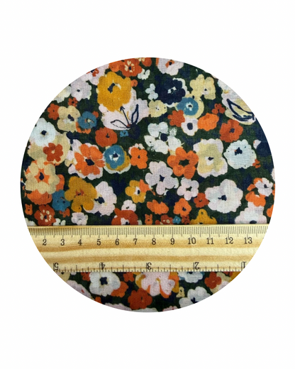 A circular swatch of Meadow from Sunday Collection for Cloud9 Fabrics, with a wooden ruler in centimeters for scale on a white background.