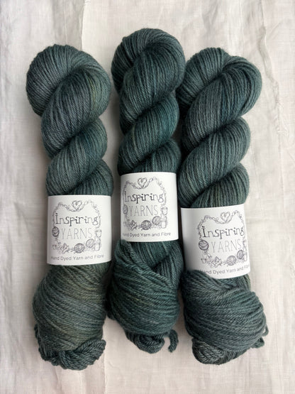 Three skeins of dark green tonal yarn labelled Inspiring Yarns on a white background