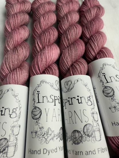 close up of 4 light dusky pink mini skeins with inspiring yarns label on white background. 