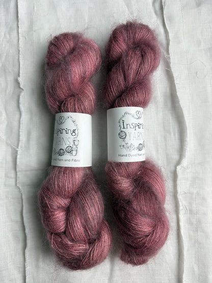 three skeins of dusty pink yarn with white inspiring yarns labels 