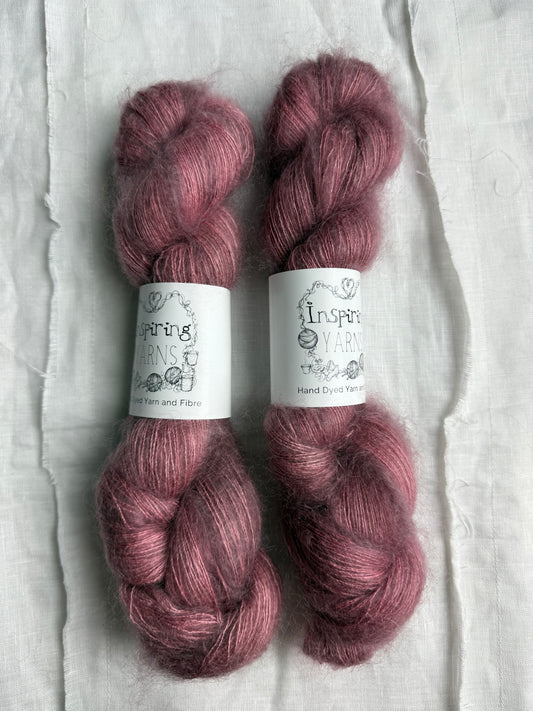 three skeins of dusty pink yarn with white inspiring yarns labels 