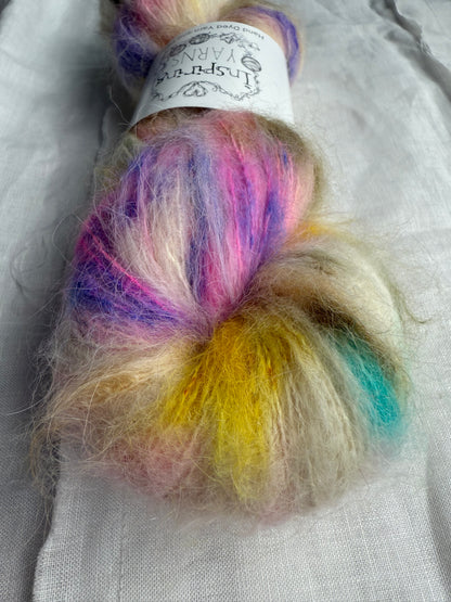 up close of skein of fluffy yarn with natural base and multicoloured speckles on a white background 