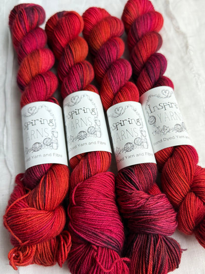Four skeins of red variegated yarn labelled Inspiring Yarns on a white background