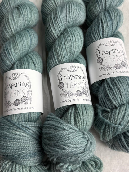 Three skeins of pale teal yarn labelled Inspiring Yarns on a white background