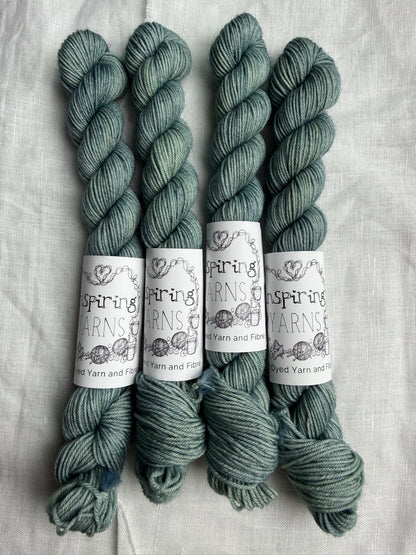 Four skeins of yarn in a teal colour with 'Inspiring Yarns' labels on a white background.