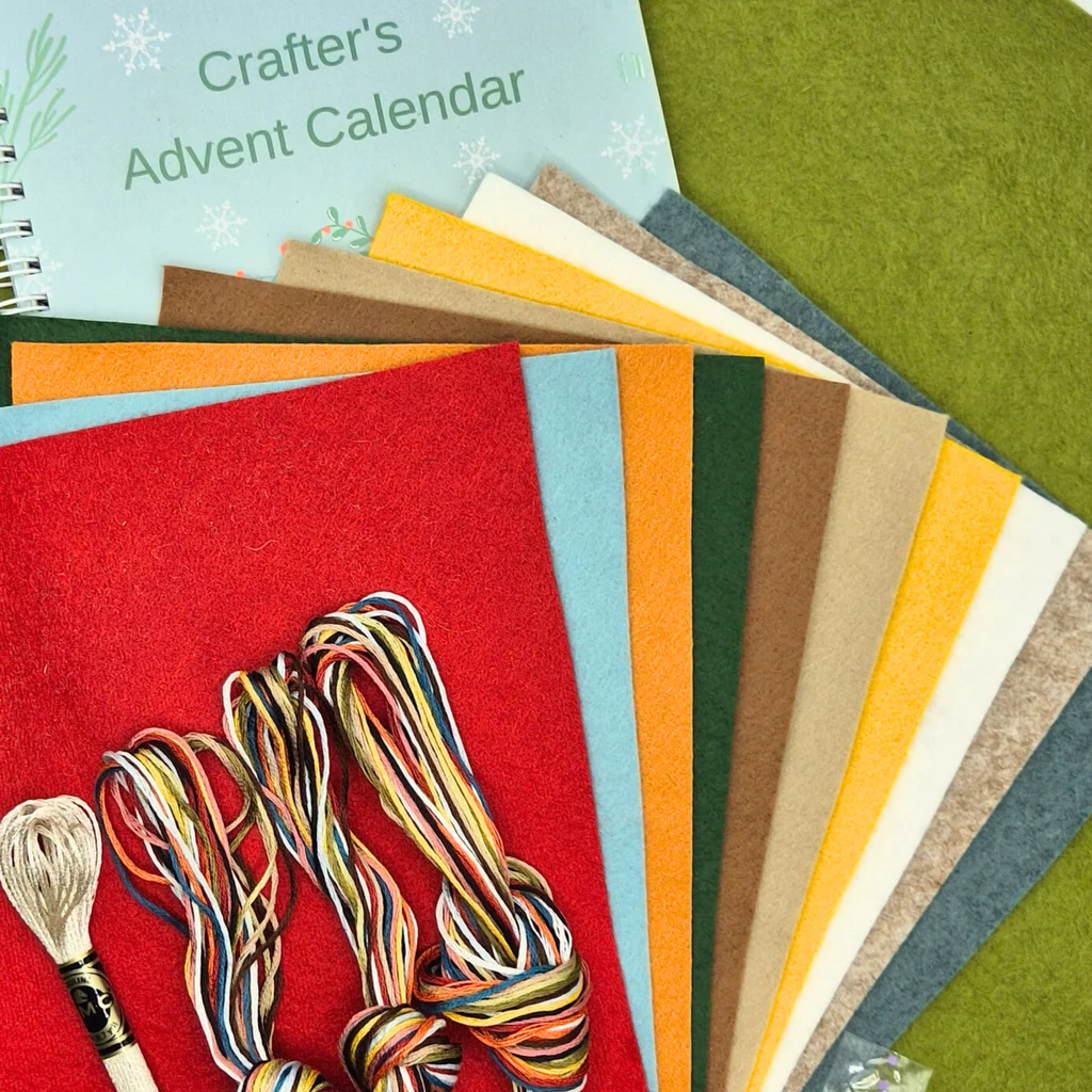 Craft materials including felt sheets and yarn on a red background with 'Crafter's Advent Calendar' text.