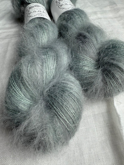 Two skeins of gray yarn on a light background. 