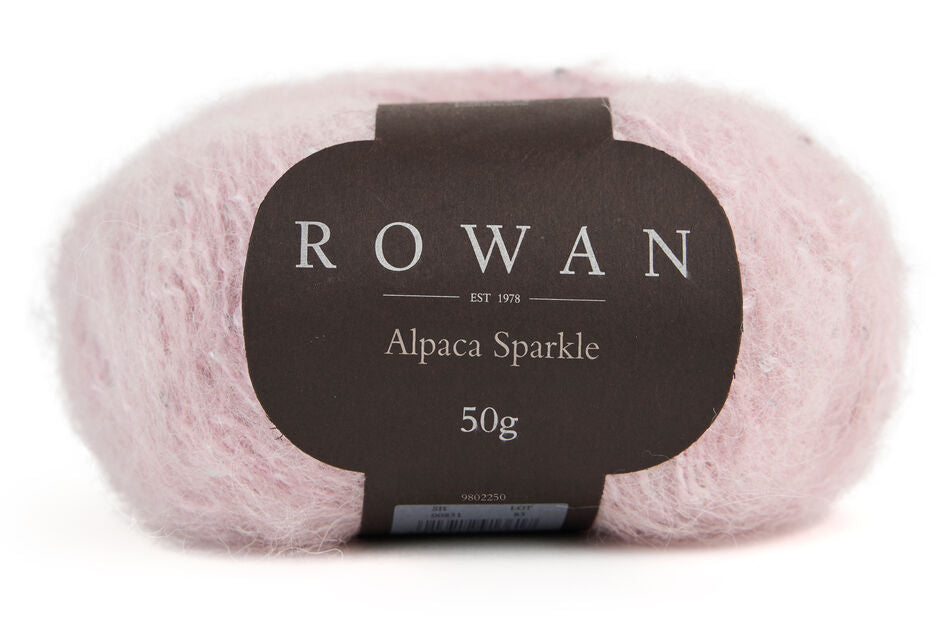 Ball of pink sparkle yarn with black rowan label and grey writing on a plain white background. 