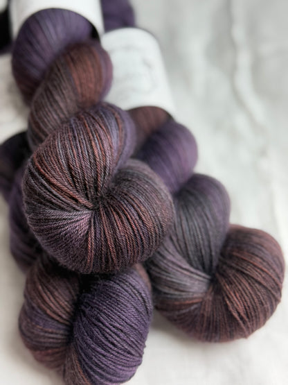 up close of dark purple yarns with orange and blue tones.
