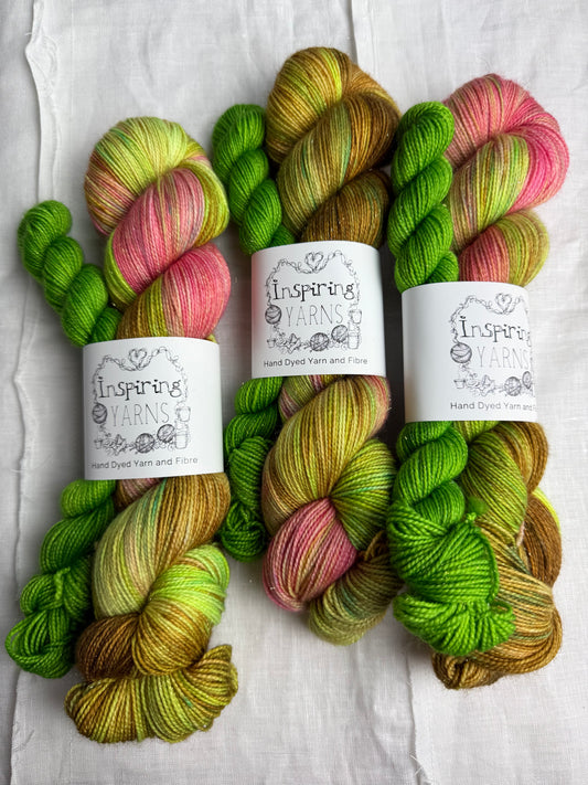 Three skeins of multi-coloured yarn with labels on a white fabric 
