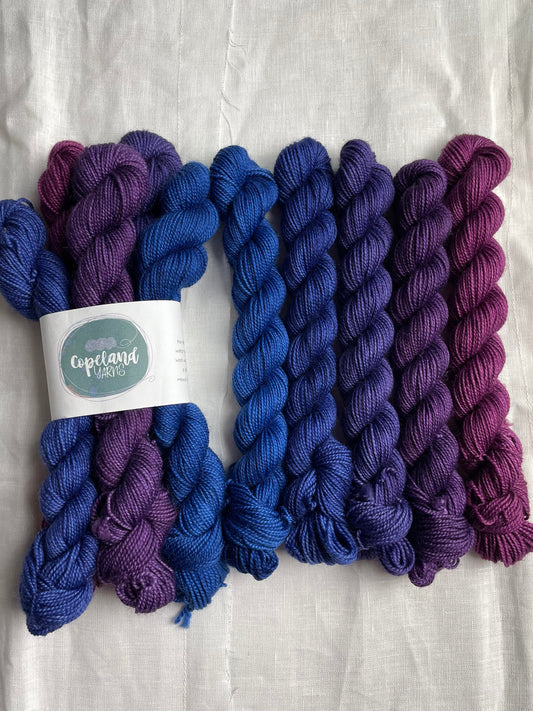  2 sets of 5 mini skeins in a blue to purple fade by Copeland Yarns on a white background