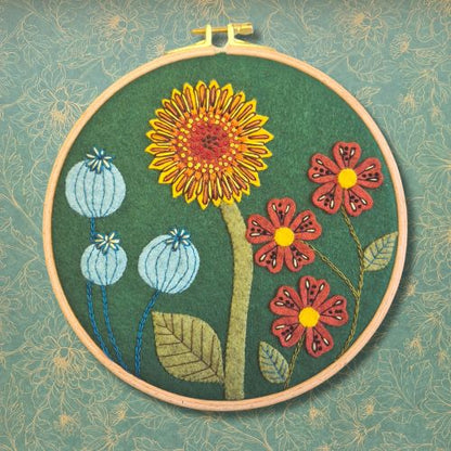 Embroidery hoop with floral design on a textured green background