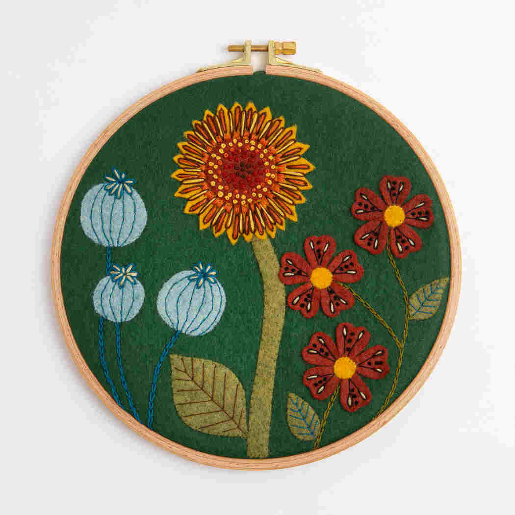 Embroidery hoop with floral design on a green background