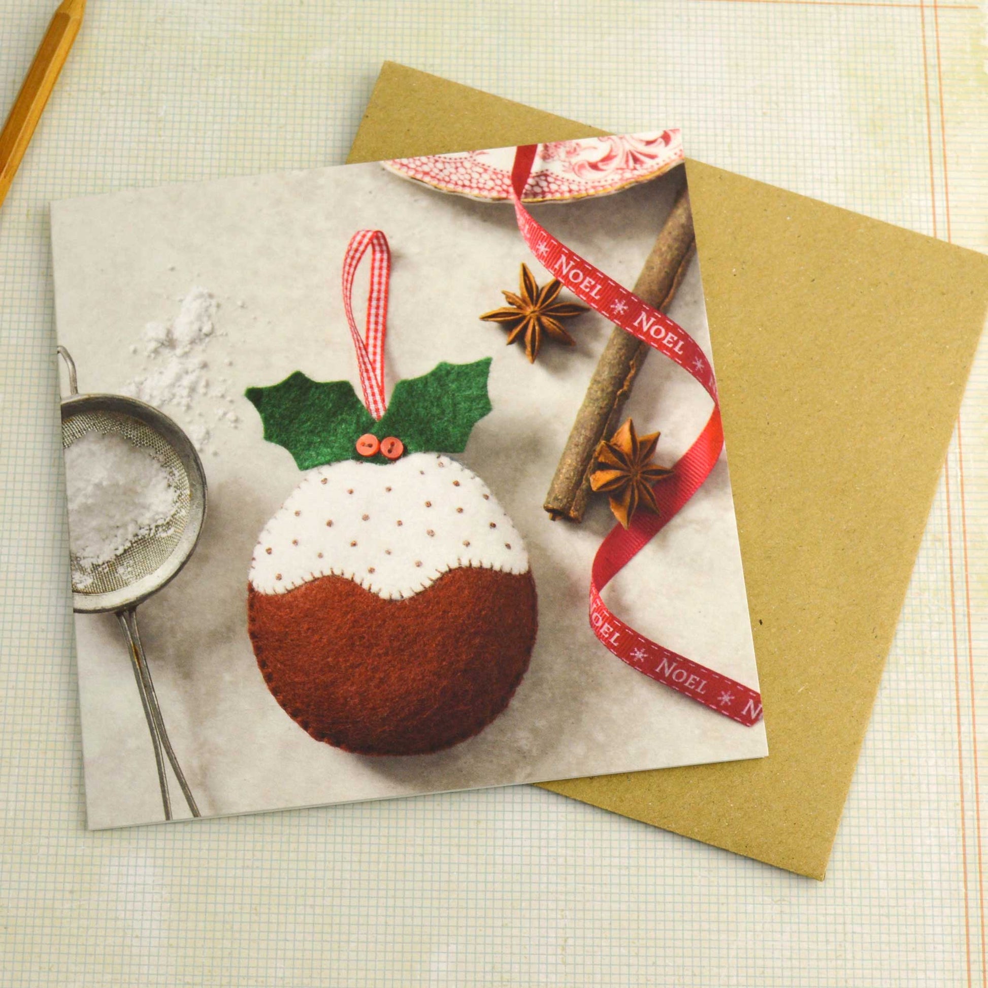 Christmas-themed card with a decorative pudding ornament on a white surface 