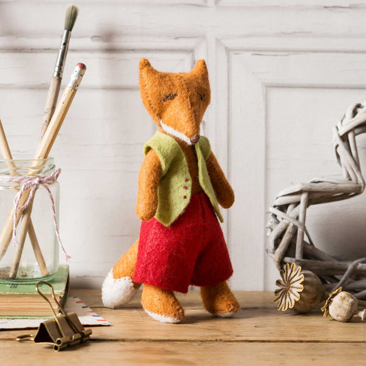 stuffed felt fox character with red shorts and a green waist coat .