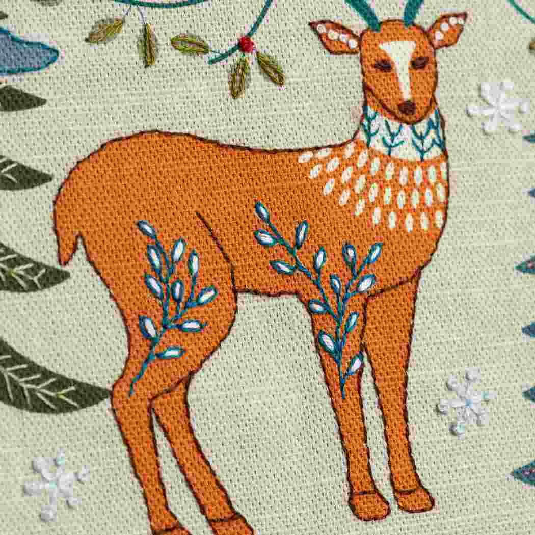 Close up of a deer design on a linen fabric background with hand embroidered embellishments