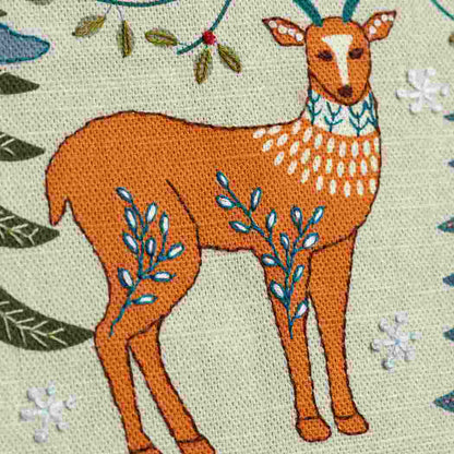 Close up of a deer design on a linen fabric background with hand embroidered embellishments