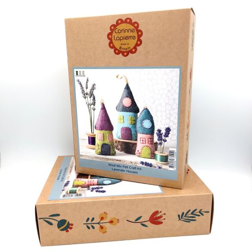 Cardboard box with Corinne Lapierre branding containing craft materials for making colorful houses.