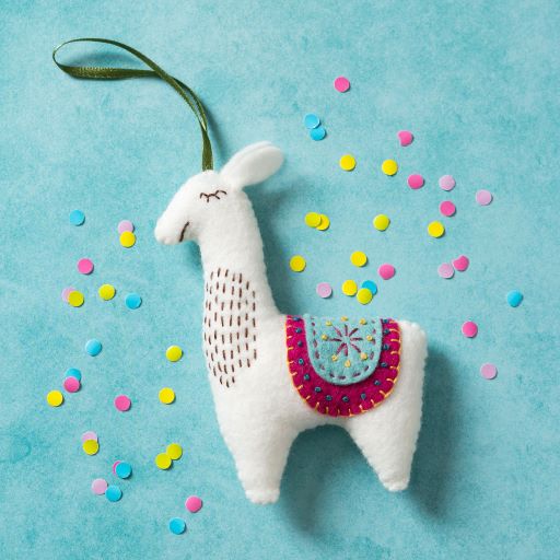 white decorative llama on a plain blue background with scattered confetti. 