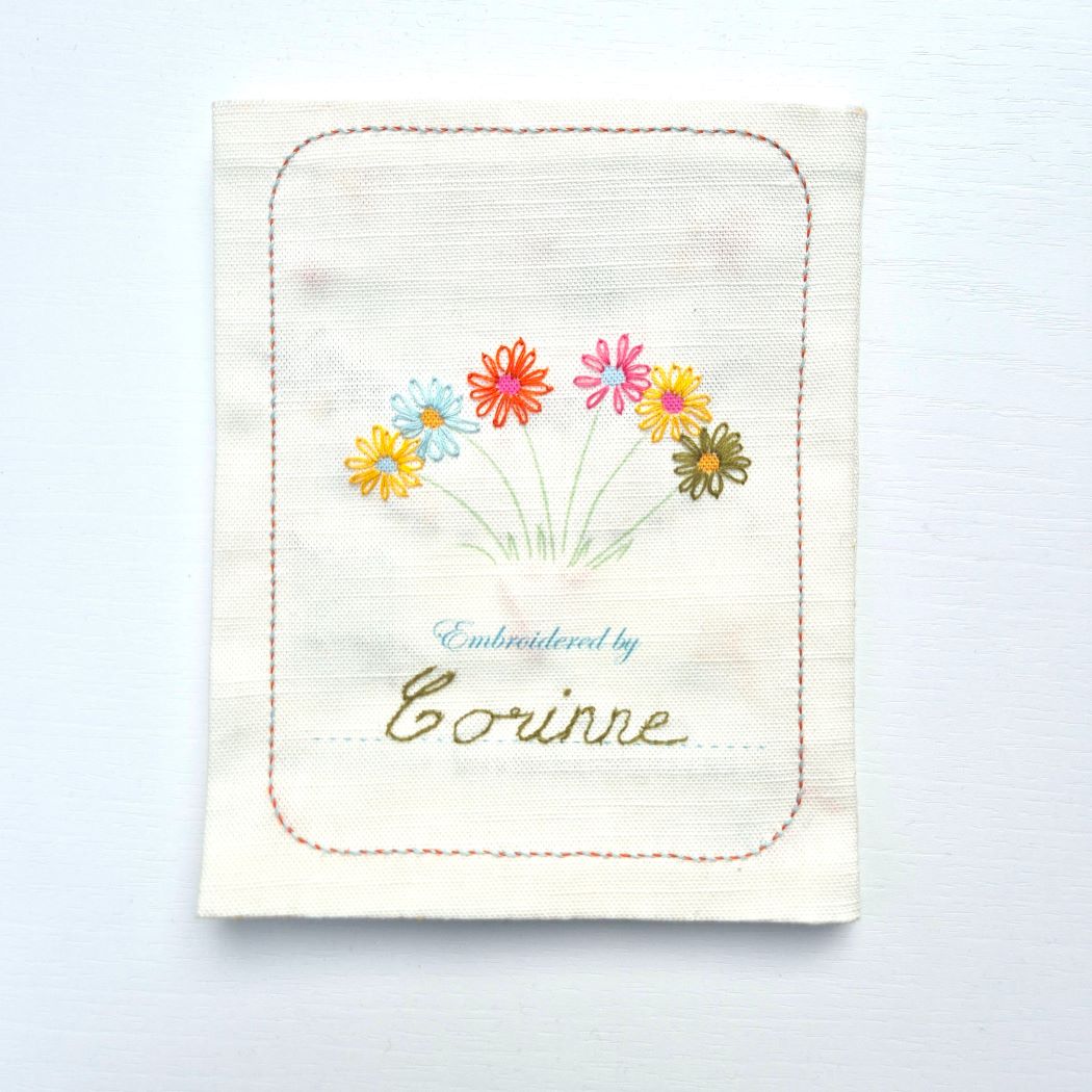 cover of sampler book with flowers and "embroidered by corinne" on the front.