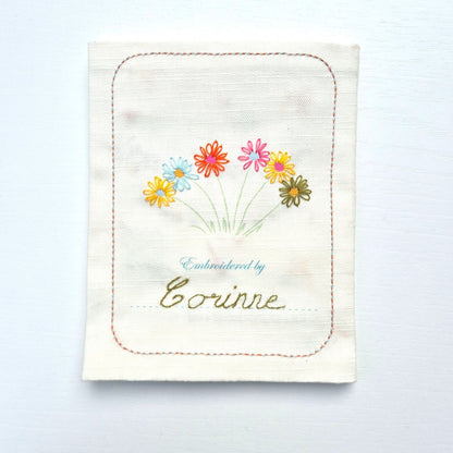 cover of sampler book with flowers and "embroidered by corinne" on the front.
