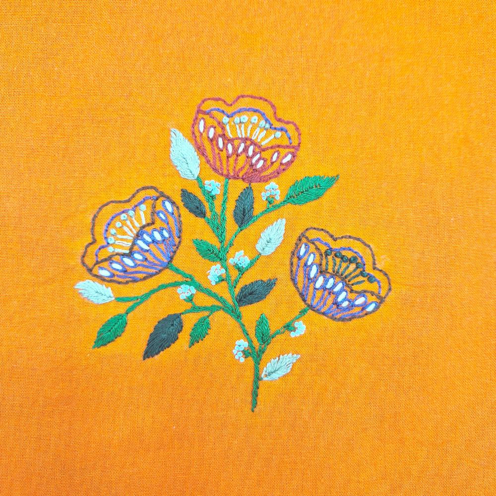 colourful embroidered flowers on yellow fabric. 