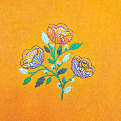 colourful embroidered flowers on yellow fabric. 