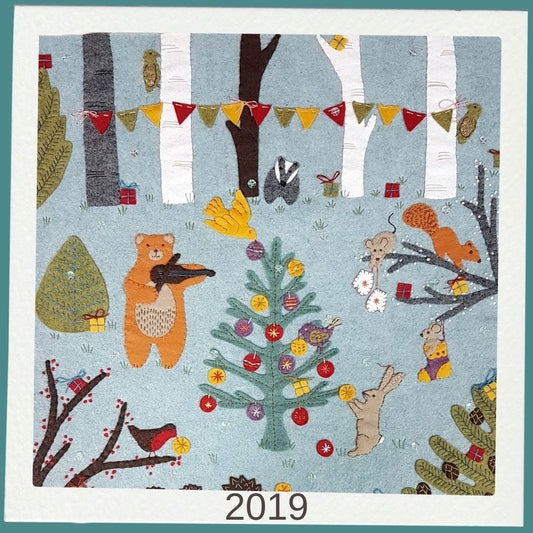 stitched felt  scene with animals around a Christmas tree, featuring the year 2019.