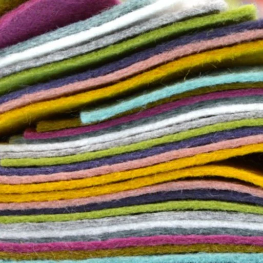 stacks of colourful felt up close in an assortment of colours.