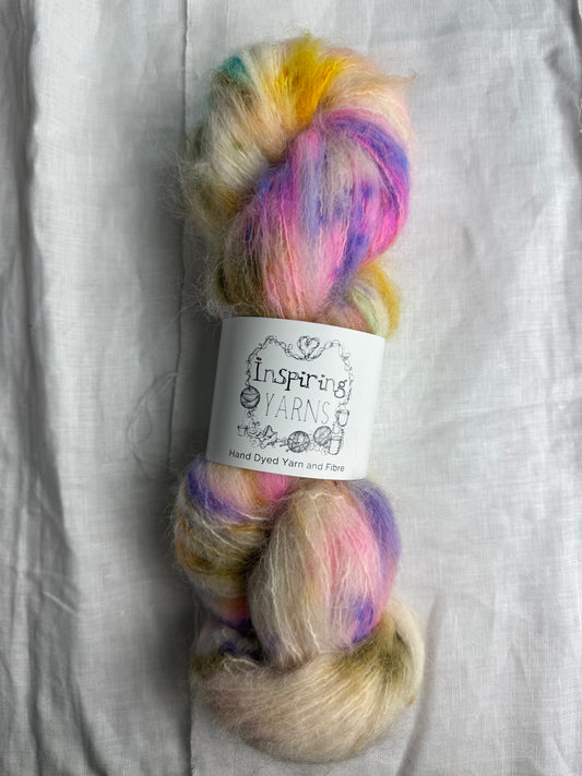 skein of fluffy yarn with natural base and multicoloured speckles with inspiring yarns label on a white background.