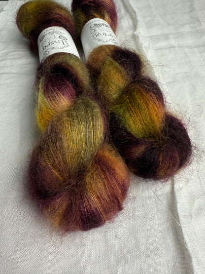 Two skeins of multicolored yarn on a white fabric background